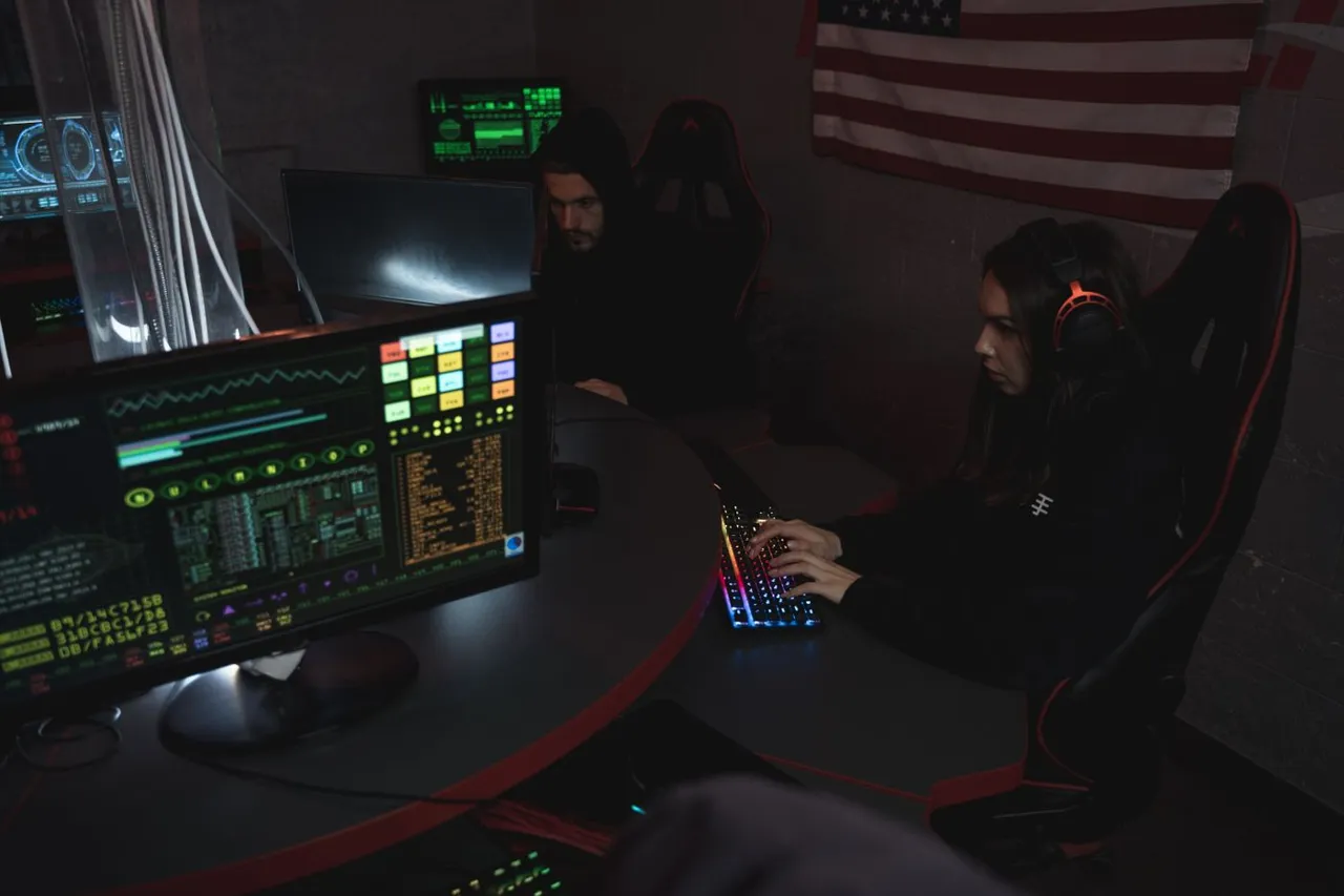 Security analyst at a keyboard beside monitors showing live system dashboards